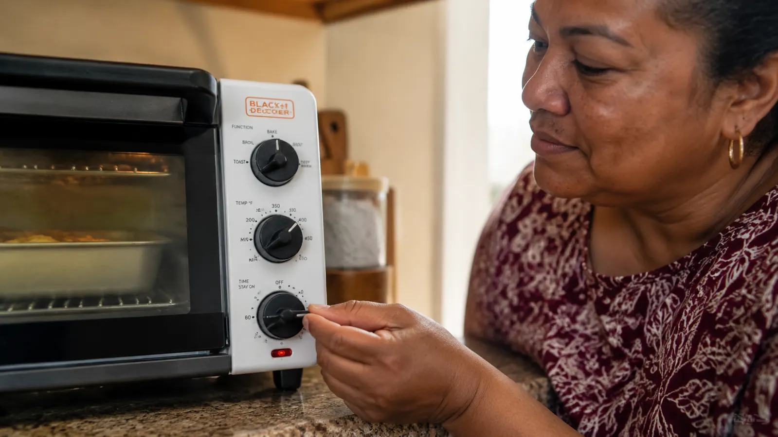 Close-up of a toaster oven dial turned to bake setting with a simple timer knob