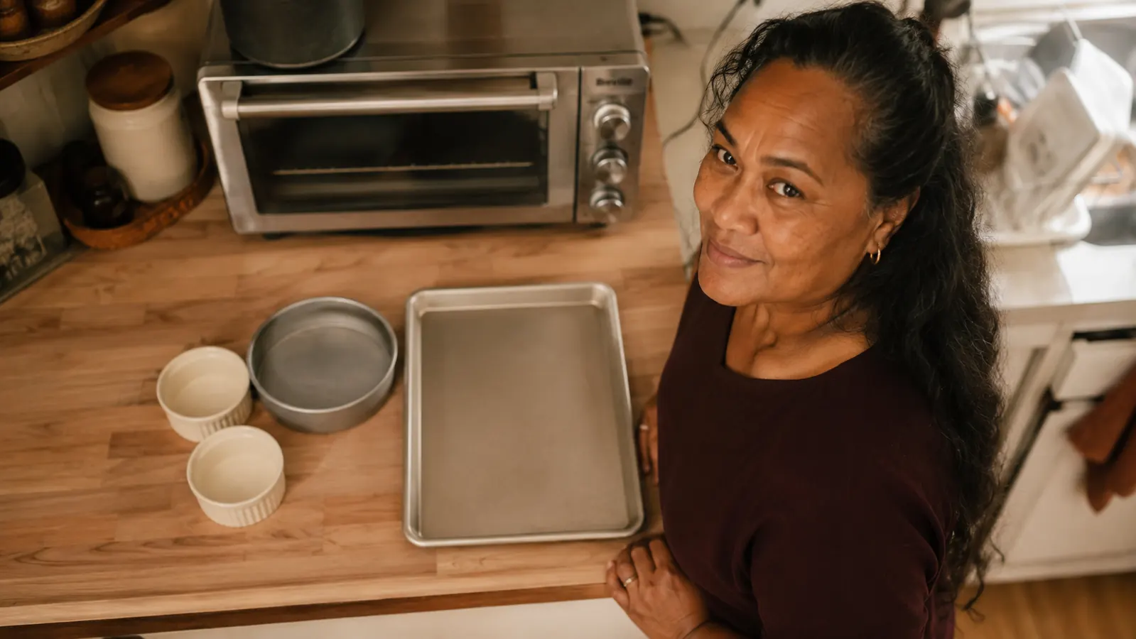Small ramekins and a 6-inch round pan laid out on a kitchen counter next to a toaster oven